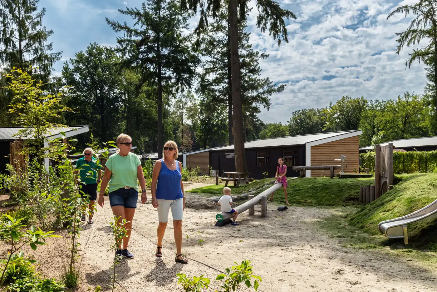Wandelaars en spelende kinderen bij de natuurspeeltuin